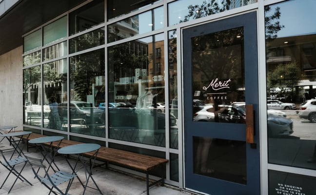 Merit Coffee shop exterior in Austin with bistro tables and mature trees