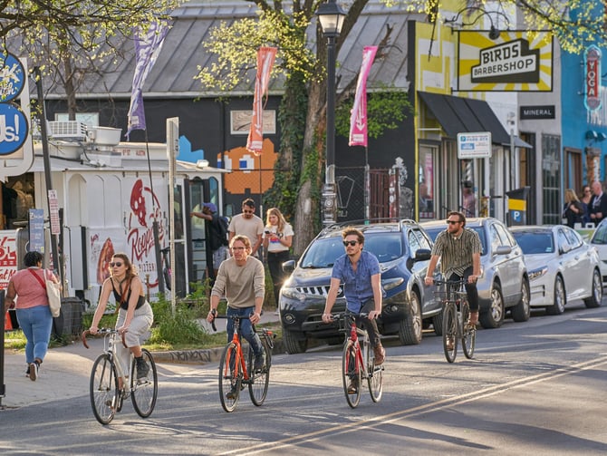 Cyclists on a sunny East Austin street during SXSW